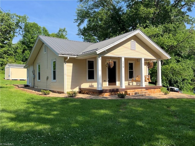 219 Highland Ave, Elkin, NC 28621 - view of front of property with covered porch, a front lawn, and metal roof