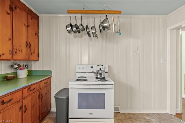 kitchen featuring brown cabinetry, white range with electric stovetop, and light countertops