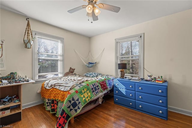 bedroom with wood-type flooring, ceiling fan, and baseboards