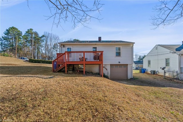 rear view of house with a garage, a wooden deck, stairs, and a yard