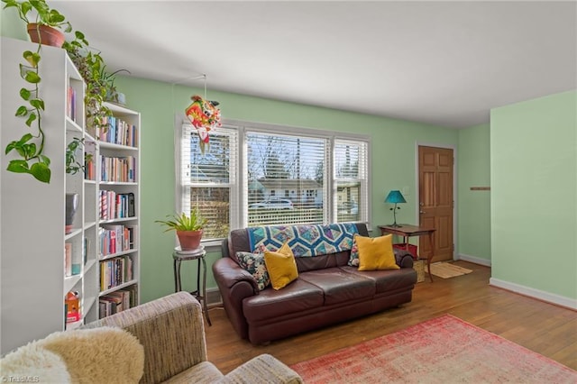 living area with baseboards and wood finished floors