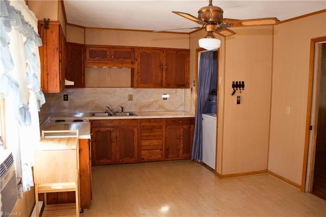 kitchen with tasteful backsplash, sink, light hardwood / wood-style floors, ceiling fan, and ornamental molding