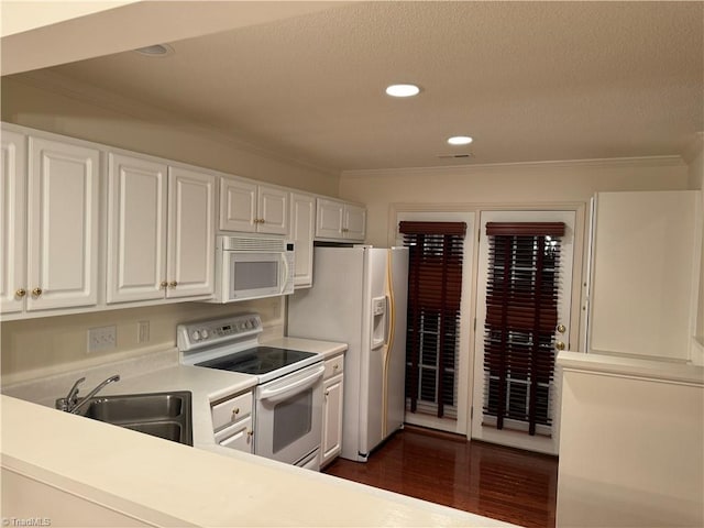 kitchen with crown molding, white cabinets, white appliances, sink, and dark hardwood / wood-style floors