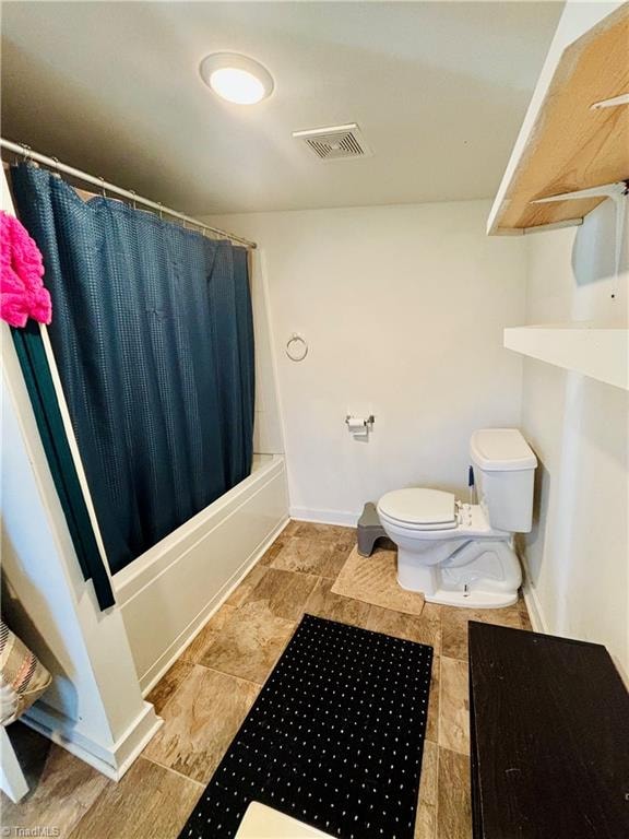 bathroom featuring shower / bath combo with shower curtain and toilet