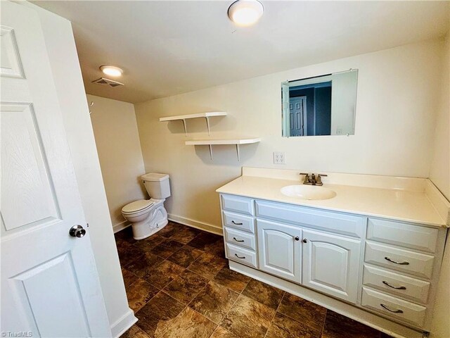 1699 W Pine St, Mount Airy, NC 27030 - bathroom with vanity, toilet, stone finish floors, and baseboards