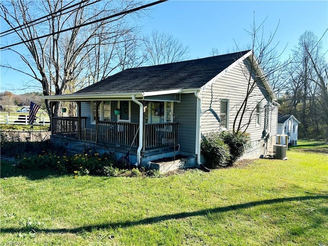 view of front of house with a porch, central air condition unit, and a front lawn