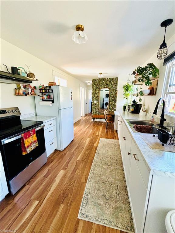1699 W Pine St, Mount Airy, NC 27030 - kitchen featuring electric range, a sink, light wood finished floors, white cabinets, and light countertops