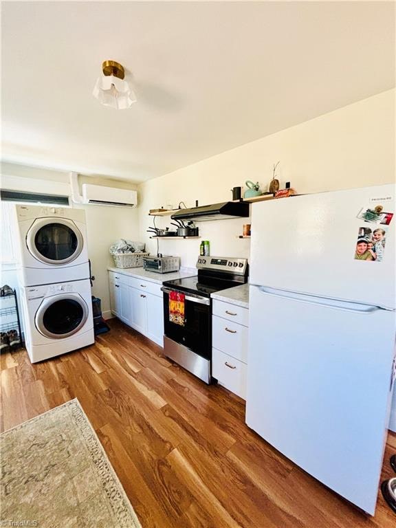 kitchen with hardwood / wood-style floors, stainless steel range with electric cooktop, white cabinets, white refrigerator, and stacked washer / dryer