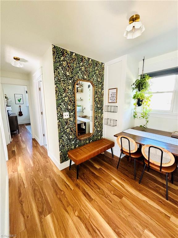 1699 W Pine St, Mount Airy, NC 27030 - hallway with wallpapered walls, light wood finished floors, an accent wall, and baseboards