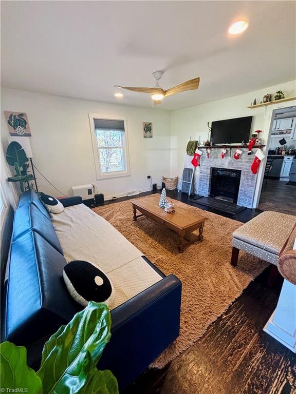 living room featuring ceiling fan and dark wood-type flooring