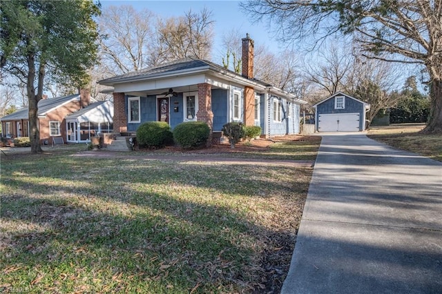 view of front of house featuring an outbuilding, a garage, and a front yard