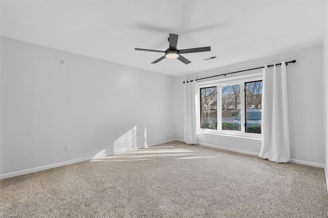 empty room with carpet floors, baseboards, visible vents, and ceiling fan