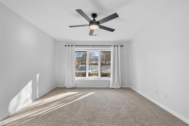 unfurnished room featuring carpet floors, a ceiling fan, and baseboards