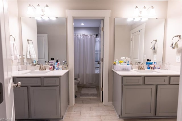 full bathroom with two vanities, a sink, and toilet