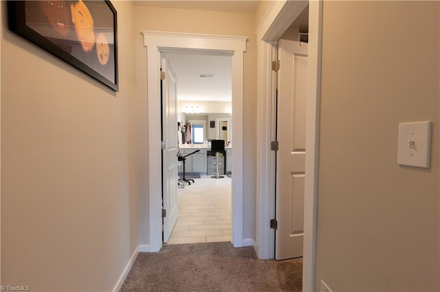 corridor with light colored carpet and baseboards