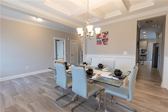 dining room featuring light wood-style floors, beam ceiling, crown molding, and an inviting chandelier