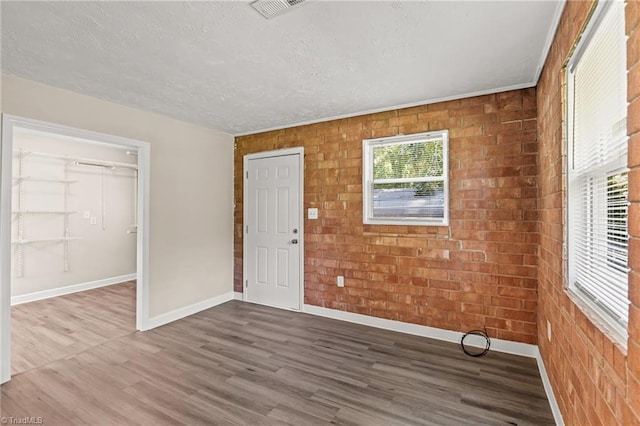 5054 Meadowbrook Dr, Trinity, NC 27370 - foyer featuring wood finished floors, brick wall, and a textured ceiling