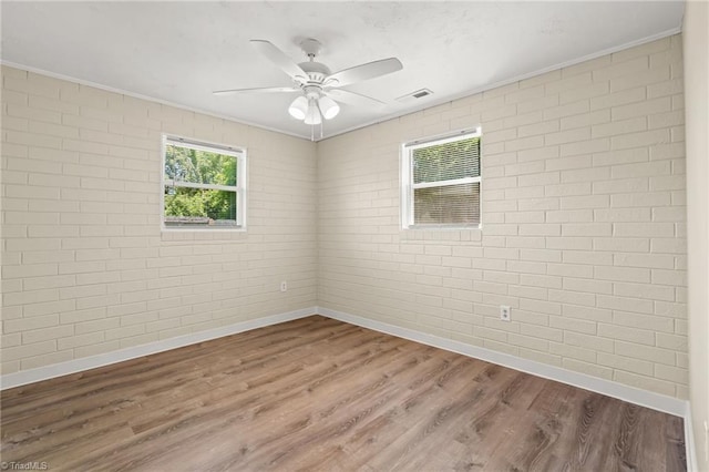 5054 Meadowbrook Dr, Trinity, NC 27370 - spare room with wood finished floors, ceiling fan, crown molding, and brick wall