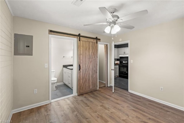 5054 Meadowbrook Dr, Trinity, NC 27370 - unfurnished bedroom with electric panel, a barn door, wood finished floors, ensuite bathroom, and ceiling fan