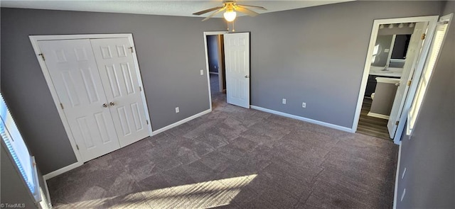 unfurnished bedroom featuring connected bathroom, ceiling fan, a closet, and dark colored carpet