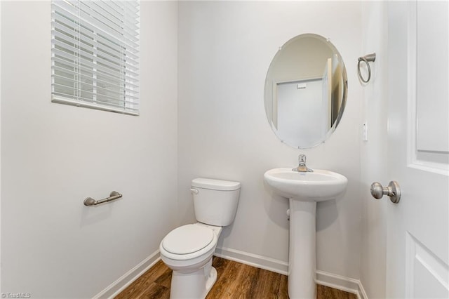 bathroom with wood-type flooring, sink, and toilet