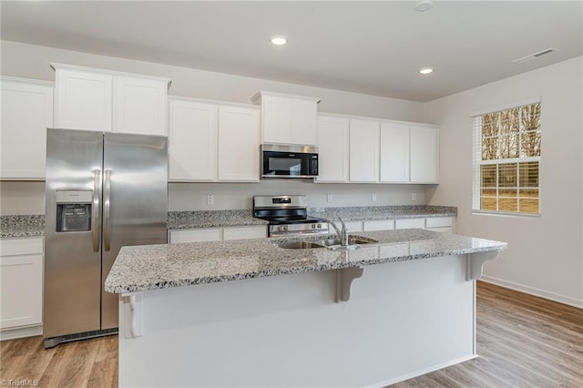 kitchen featuring a kitchen island with sink, sink, white cabinetry, and stainless steel appliances