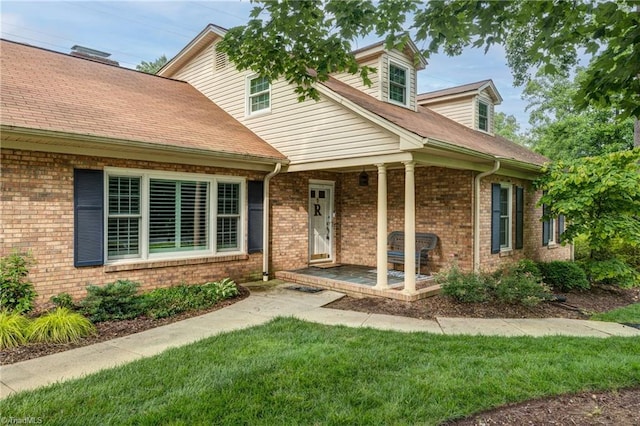 1317 Longcreek Dr, High Point, NC 27262 - view of front facade with brick siding, a front lawn, a porch, and a shingled roof