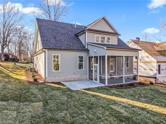 back of house with a yard, roof with shingles, and a patio