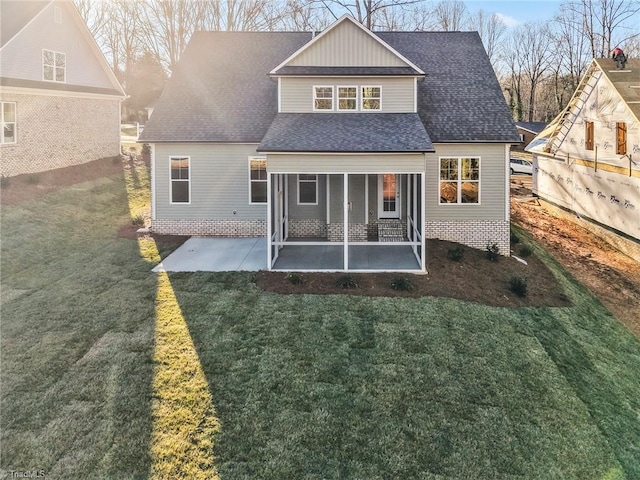 rear view of house with a yard, roof with shingles, and a patio area