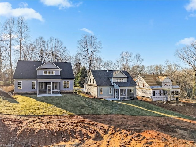 back of property featuring a yard, a patio area, and a sunroom