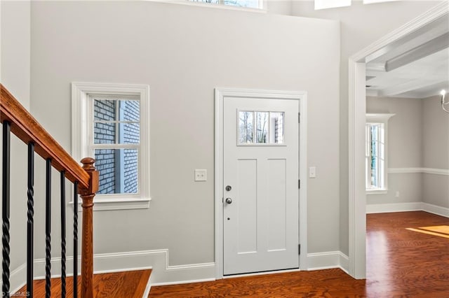 foyer featuring stairs, wood finished floors, and baseboards