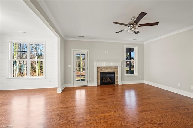 unfurnished living room with a healthy amount of sunlight, crown molding, and wood finished floors