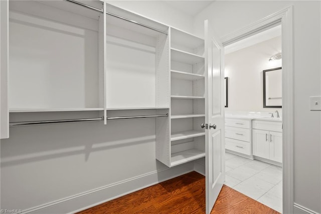 walk in closet featuring light wood-style floors and a sink