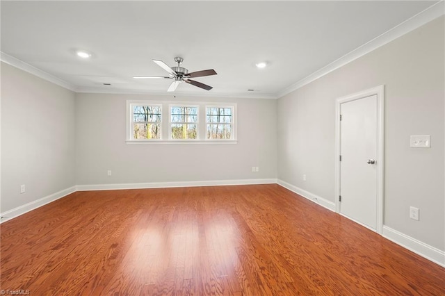 empty room with ceiling fan, ornamental molding, wood finished floors, and baseboards