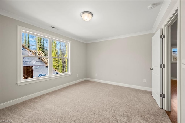 unfurnished room featuring ornamental molding, light colored carpet, visible vents, and baseboards