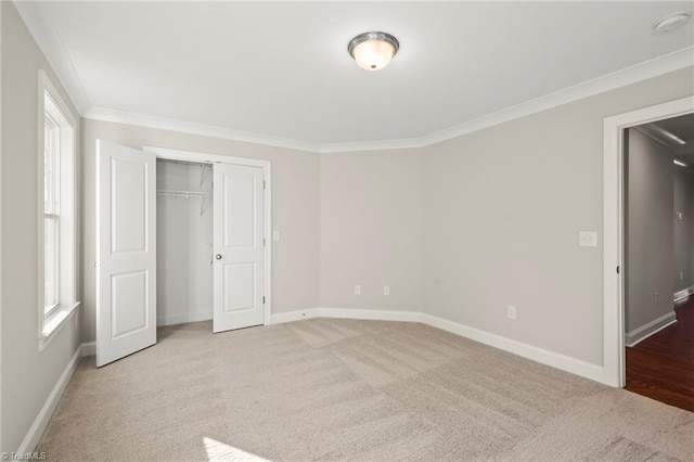 unfurnished bedroom featuring ornamental molding, carpet, a closet, and baseboards