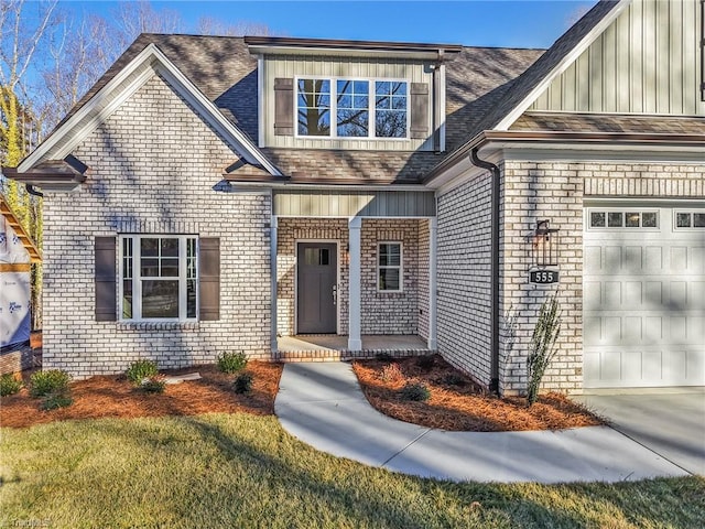 entrance to property featuring board and batten siding, brick siding, an attached garage, and roof with shingles