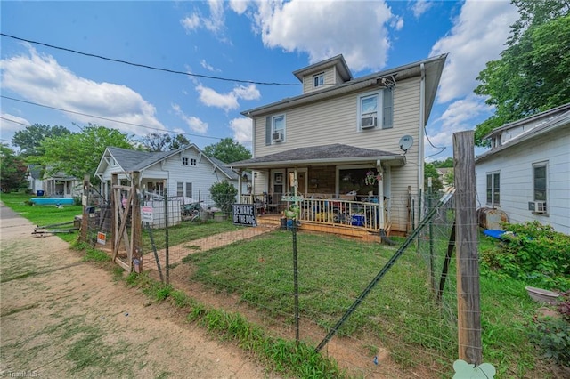 rear view of property featuring cooling unit, a yard, and covered porch