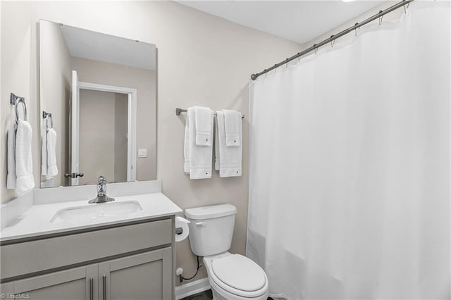 bathroom featuring baseboards, vanity, and toilet