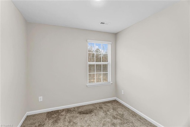 unfurnished room featuring carpet, visible vents, and baseboards