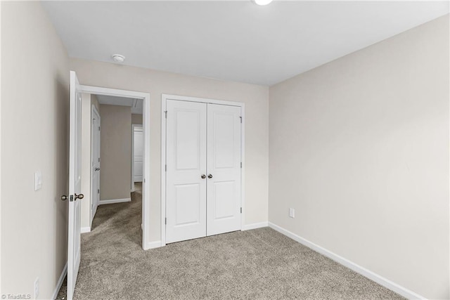 unfurnished bedroom featuring a closet, carpet flooring, and baseboards