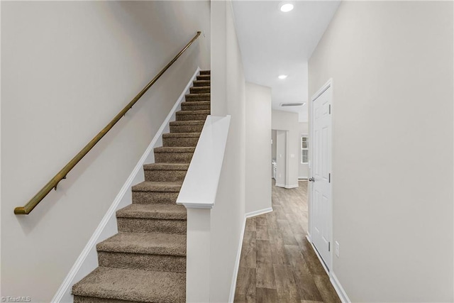 stairway with recessed lighting, baseboards, and wood finished floors