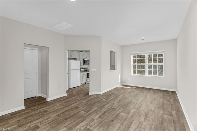 empty room with baseboards and dark wood-type flooring