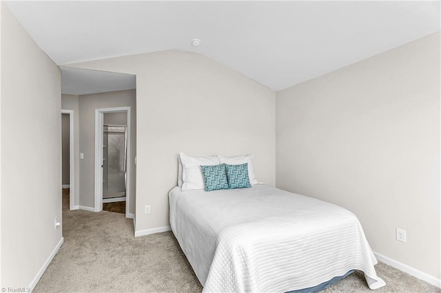 carpeted bedroom featuring vaulted ceiling and baseboards