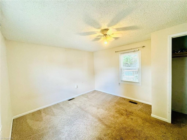 unfurnished bedroom with carpet floors, a textured ceiling, baseboards, a closet, and a ceiling fan