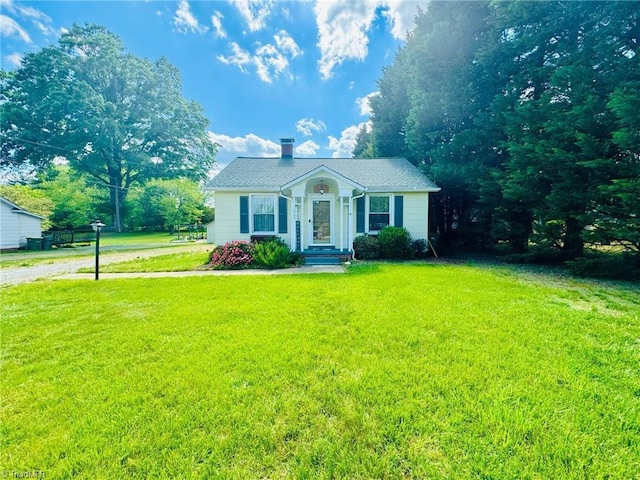 view of front of home featuring a front yard and a chimney