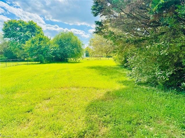 view of yard featuring fence and a view of rural / pastoral area