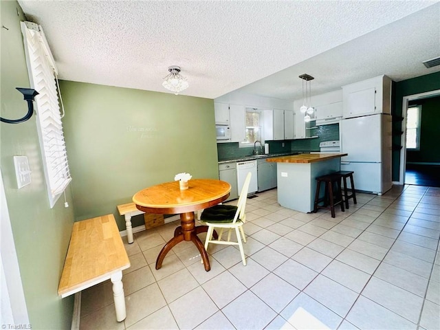 dining room with plenty of natural light, a textured ceiling, and light tile patterned floors