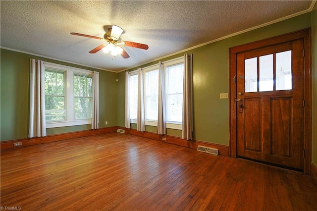 foyer entrance with ceiling fan, hardwood / wood-style flooring, a textured ceiling, and ornamental molding