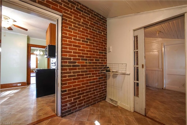 hall featuring crown molding, brick wall, and lofted ceiling